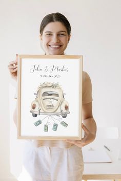 a woman holding up a framed photo with an old vw bug in the background