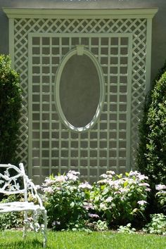 a white bench sitting in front of a wall with a circular mirror on it's side