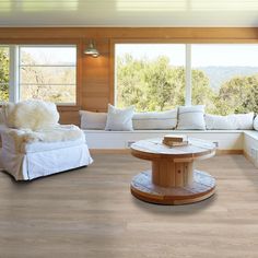 a living room filled with furniture and lots of windows overlooking the trees in the distance