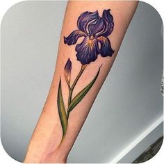 a purple flower with green leaves on the left forearm and right arm, is shown