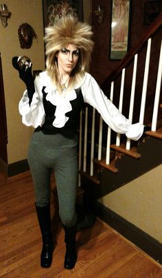 a woman standing in front of a staircase with her arms out and hair blowing back