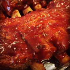 ribs covered in bbq sauce sitting on top of potatoes