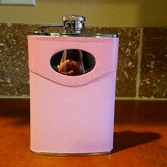 a pink leather flask with a woman's hand sticking out of the pocket