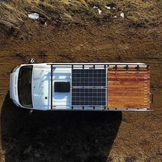 an aerial view of a vehicle with solar panels on the roof, parked in a field