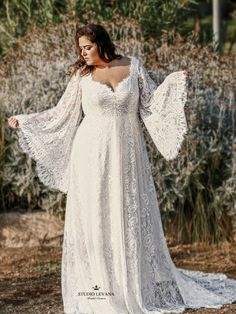 a woman in a white dress is standing outside