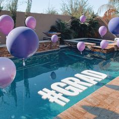 balloons are floating in the air next to a swimming pool with an adora sign on it