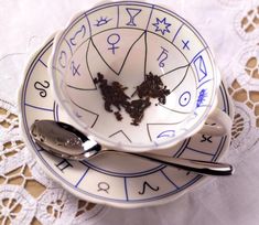 two cups with spoons on top of them sitting in front of an astro wheel