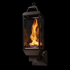 an outdoor fireplace with flames burning in the dark, against a black background that appears to be lit