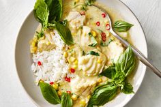 a white plate topped with rice and meat covered in green leafy garnish