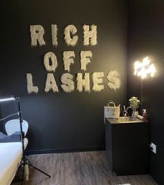 a room with black walls and white writing on the wall that says, rich off lashes