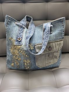 a purse made out of old jeans is sitting on a couch