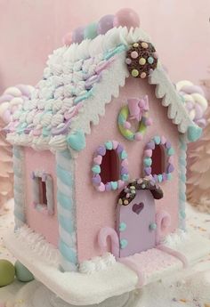 a pink and blue house with decorations on the roof