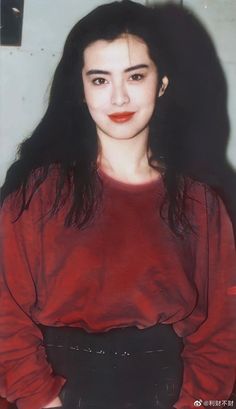 a woman with long black hair wearing a red shirt