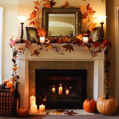 a fireplace decorated with candles and fall leaves