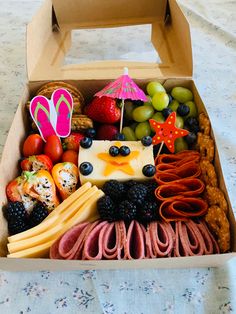 a cardboard box filled with different types of food and fruit on top of a table