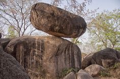 large rocks are stacked on top of each other with trees in the backgroud