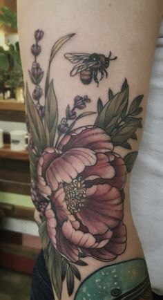 a woman's thigh with flowers and a bee on it