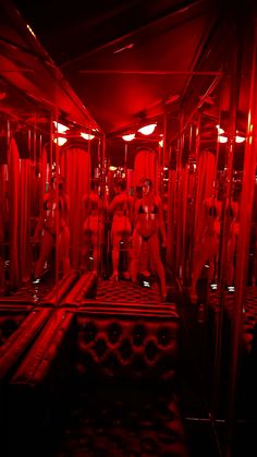 a group of men in white suits and red lights on a subway car with mirrors