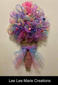 this is an image of a bouquet made out of mesh and ribbons on a wall