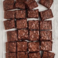 chocolate brownies cut into squares on top of parchment paper