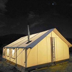 a tent is lit up at night with the moon in the sky and stars above it