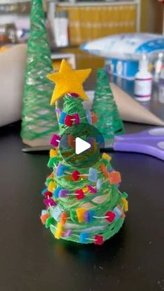 a small christmas tree made out of plastic beads and colored pencils on a table