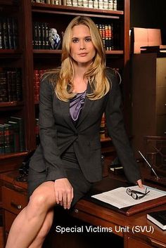 a woman in a suit sitting at a desk