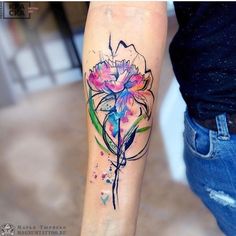 a woman's arm with a flower tattoo on it