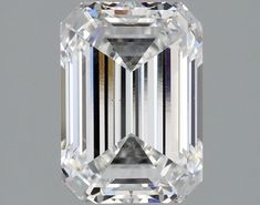 an emerald cut diamond is displayed on a gray background with the reflection of it's face