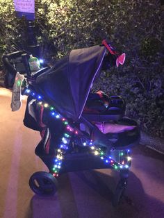 a stroller is decorated with christmas lights