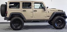 a beige jeep is parked in a room with checkered flooring and white walls