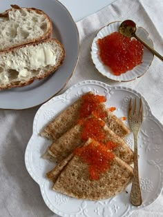 there are three pieces of bread with sauce on them next to a fork and knife