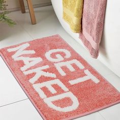 a bathroom rug with the words bath mat written in white letters on it, next to a tub