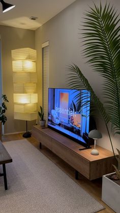 a flat screen tv sitting on top of a wooden entertainment center in a living room