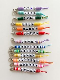 six key chains with words written on them in different colors and sizes, all lined up next to each other