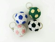 three crocheted keychains with soccer balls on them sitting next to each other