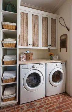 a washer and dryer in a small room with brick flooring on the walls