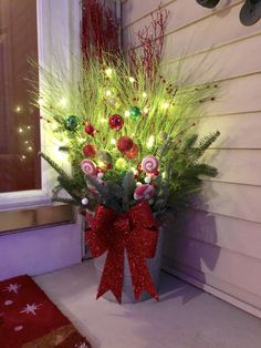 a potted plant decorated with candy canes and christmas lights on the front porch