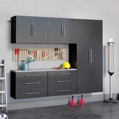 a kitchen with gray cabinets and tools hanging on the wall next to it's workbench