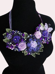 a woman wearing a purple necklace with flowers on it