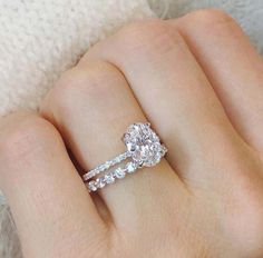 a woman's hand with two engagement rings on it