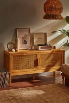 a wooden sideboard sitting on top of a floor next to a potted plant