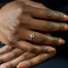 a close up of a person's hand with a diamond ring on their finger