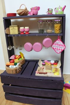 a toy kitchen with pots and pans on the shelves