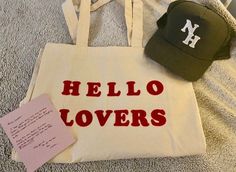 a tote bag, hat and note are on the floor