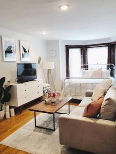 a living room filled with furniture and a flat screen tv on top of a wooden table