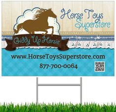 the horse toy store sign is in front of green grass and blue sky with clouds