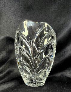 a clear glass vase sitting on top of a black cloth