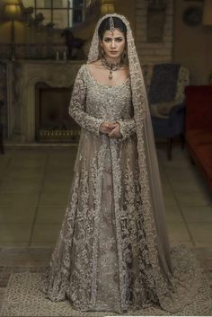 Pakistani Walima Bridal Dress in Ivory Color with Magnificent Look emblazoned with beautiful embroidery, dabka and sequins. This lehnga is unique in style and have classy look and perfect choice for traditional bride. Maxi: Top long Maxi for bridal lehnga in ivory color is embellished with fully copper color embroidery, dabka, nakshi, stones, cutdana, crystals work. Neckline is decor with Full length Sleeves have a embroidery. Fabric used for choli is chiffon. Lehnga: Stylish Lehnga in ivory col Nilofer Shahid, Walima Dress, Shadi Dresses, Bridal Dresses Pakistan, Pakistani Wedding Dress, Ghagra Choli, Pakistani Bridal Dresses, Pakistani Wedding Dresses, Pakistani Bridal Wear