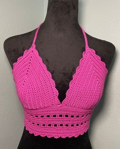 a pink crocheted halter top on a mannequin